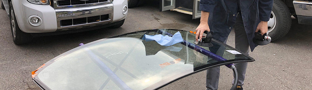 Glass technician prepares new windshield for an SUV